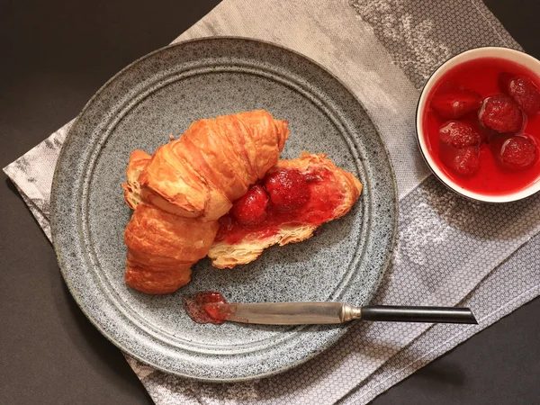 Ovanifrån Croissant Med Jordgubbssylt Och Kniv Grå Tallrik Och Jordgubbssylt — Stockfoto