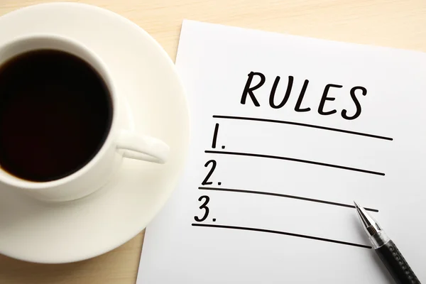 在白纸上写的规则列表 旁边放咖啡 — 图库照片