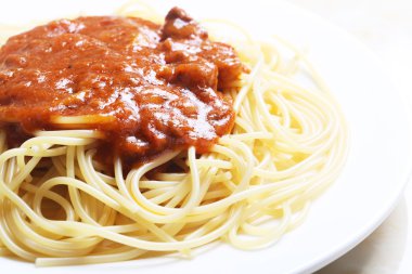 Lezzetli pişmiş spagetti beyaz plaka üzerinde çekim kapatın.