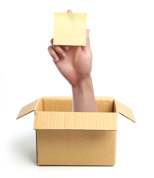 Hand with blank sticky note out of box — Stock Photo, Image