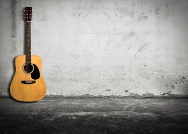 Acoustic guitar against old wall clipart