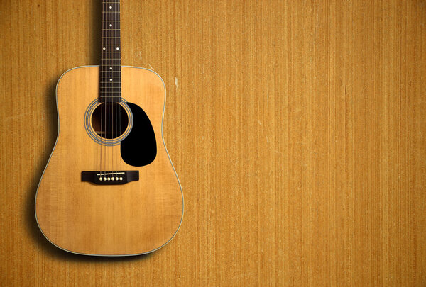 Acoustic guitar on wooden background
