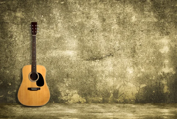 Acoustic guitar against old wall — Stock Photo, Image