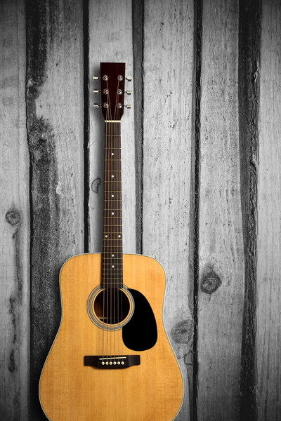 Acoustic guitar on wooden background