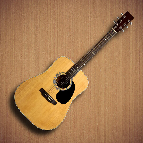 Acoustic guitar on wooden background