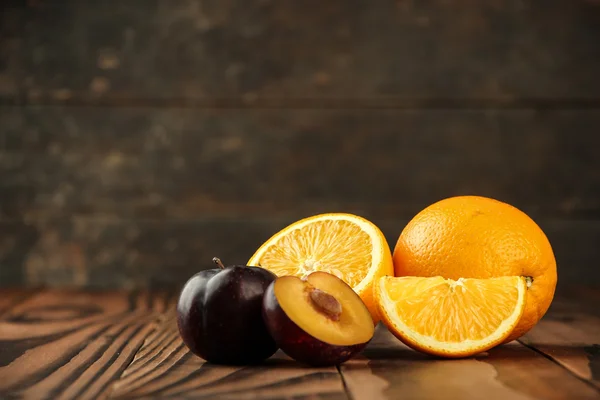 Ameixas frescas e frutas de laranja — Fotografia de Stock