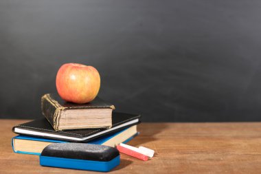 Apple, kitap ve tahta arka plan ile tebeşirler