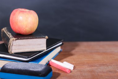 Apple, kitap ve tahta arka plan ile tebeşirler