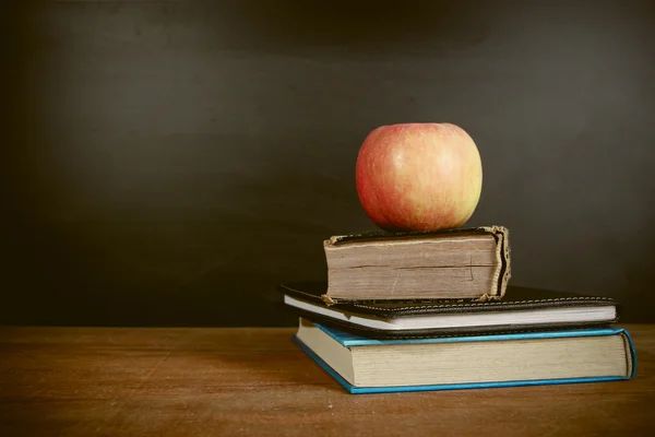 Manzana y libros con fondo de pizarra —  Fotos de Stock