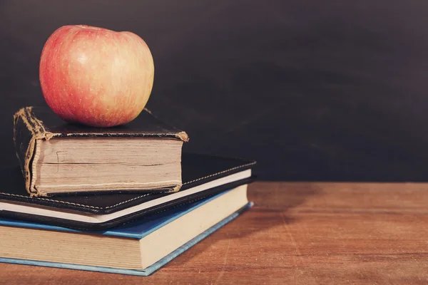 Manzana y libros con fondo de pizarra —  Fotos de Stock