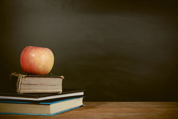 Manzana y libros con fondo de pizarra —  Fotos de Stock