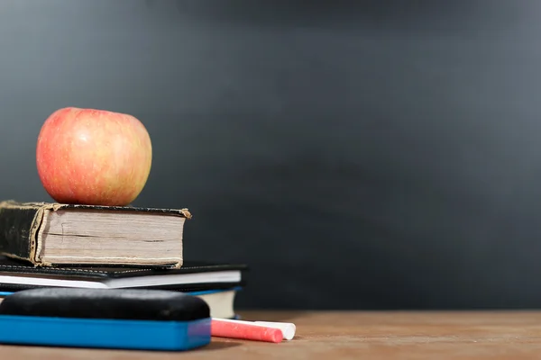 Manzana, libros y tiza con fondo de pizarra —  Fotos de Stock