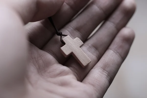 La mano sosteniendo la cruz — Foto de Stock