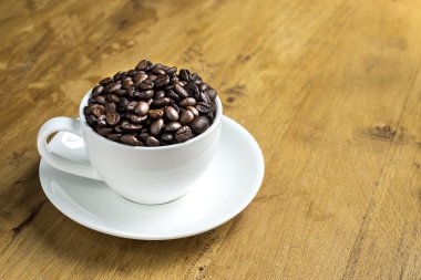 Fincan kahve çekirdekleri masada dolu