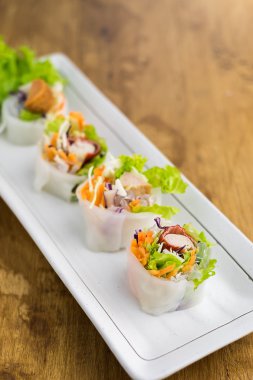 Portion of spring rolls , vegetables and in noodle tube clipart