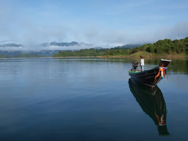 Controllo di pescatore una longtail boat sul lago Cheow Lan, Thailandia. — Foto Stock