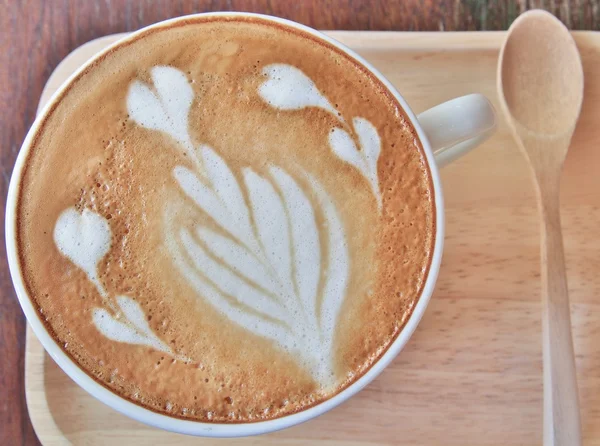 Latte Arte del café y cuchara de madera en la bandeja de madera . — Foto de Stock