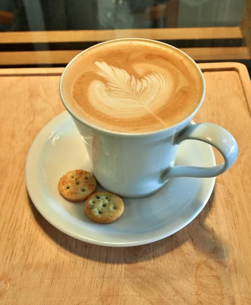 Café con leche Arte y galletas en la mesa de madera . — Foto de Stock