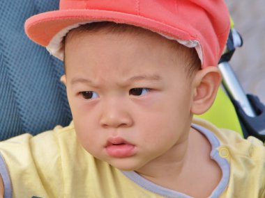 Onun yüzünde şüpheli bakışla Asya bebek