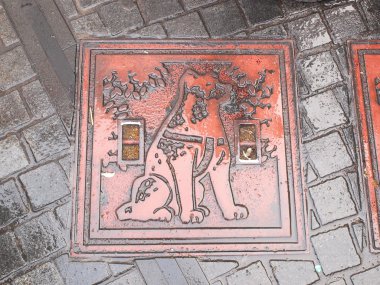 Kanalizasyon kapağı önünde Shibuya istasyonu, Tokyo - Japonya.