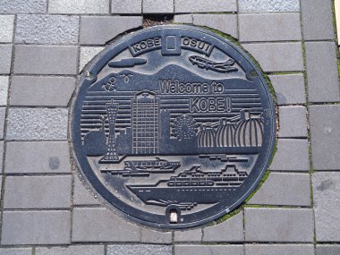 Kuyu kanalizasyon kapağının sokakta Kobe, Japonya.