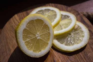Karanlık kesme tahtası üzerinde limon dilimleri
