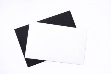 Siyah zarflı beyaz kart. Beyaz arka planda basit minimalist kompozisyon. Üst görünüm, metin için boş boşluk. Boşluğu kopyala.