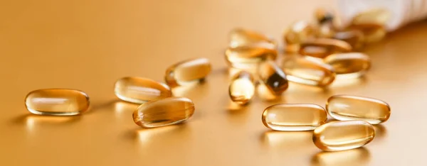 Sarı arka planda birçok Omega 3 kapsülü var. Yakın çekim, yüksek çözünürlüklü ürün. Sağlık hizmeti kavramı.