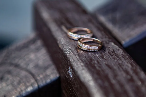 Güzel alyanslar ahşap yüzeyde yatıyor. Düğün geçmişi.