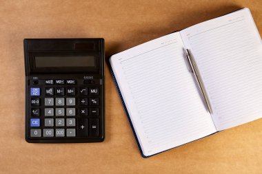 Gümüş renkli tükenmez kalemli hesap makinesi ve iş organizatörü, defter veya planlayıcı.