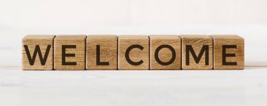 Beyaz arkaplanda tahta küplere yazılmış İleti Hoş Geldiniz.