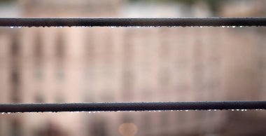 Kablo hattındaki su damlalarını kapatın. Arka planda bulanıklık var. Yağmur günü.