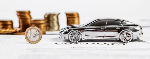 Toy car and money coins. Concept in insurance, loan, finance and buying car.