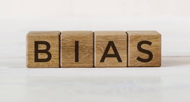 BIAS kelimesi, arka planda hafif bir arkaplan üzerine tahta küplere yazılmış harfler..