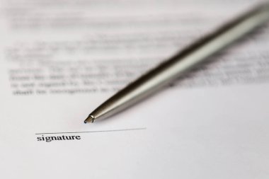 Belge ve gümüş tükenmez kalem üzerinde imza için boşluk.