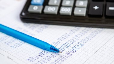 Tükenmez kalem ve hesap makinesi. Ofiste kompozisyonda iş yapmak için arkaplan ögeleri.