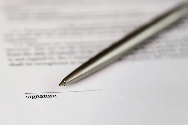 Belge ve gümüş tükenmez kalem üzerinde imza için boşluk.