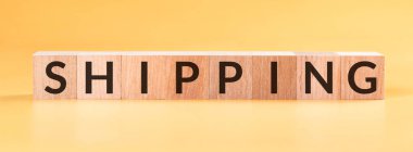 Sarı arka planda tahta küplerin inşasıyla yapılmış nakliye kelimesi.