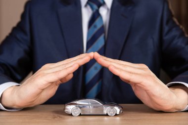 İş Adamının Eli Ofis Masasındaki Gümüş Oyuncak Arabasını Koruyor.