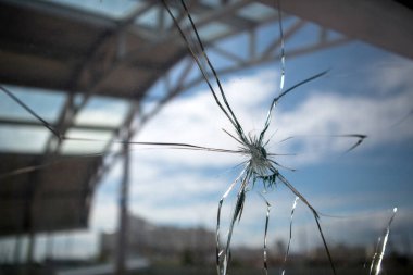 Kırık cam kırıkları mavi gökyüzü ve şehrin arka planında.