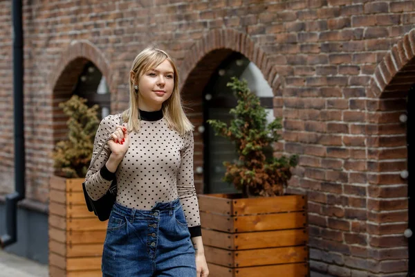 Açık havada yaşayan mutlu, çarpıcı sarışın bir kızın portresi. Şehir caddesine yürüyorum..