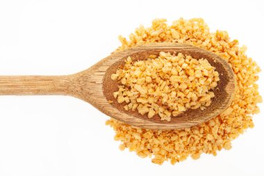 Kırsal ahşap bir kaşığa yakın plan, beyaz arka planda doku ve renkleri gösteren kızarmış sarımsak parçaları. Mutfak tasarımı, tarif çizimleri ya da yiyecek ambalajı için mükemmel.