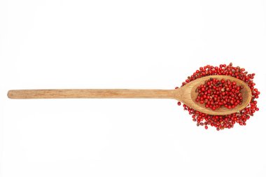 Beyaz arka planda pembe biberlerle dolu yuvarlak saplı ahşap kaşık. İzole görüntü mutfak içeriği, yemek tarifleri ya da yemek reklamları için mükemmel.