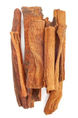 Dağınık tarçın parçalarına yakın çekim, pürüzsüz yüzeyi ve doğal kalıpları vurgulayarak temiz ve tek bir bileşim