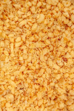 Beyaz zemin üzerinde doğranmış sarımsağın makro üst görüntüsü, çıtır çıtır dokusunu, altın rengini ve keskin odaklı her sarımsak parçasının detaylarını vurguluyor.