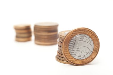 Yatay fotoğraf, Brezilya parası istiflenmiş bir fotoğraf. Gerçek paralar. Arka plan beyaz ve temiz. Ön paraya odaklan, grafik tasarımı için ideal.