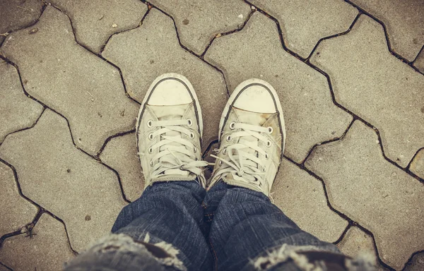 Zapatillas viejas en el pavimento de fondo — Foto de Stock
