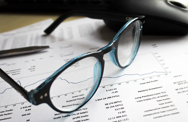 Gafas, papel financiero y pluma — Foto de Stock