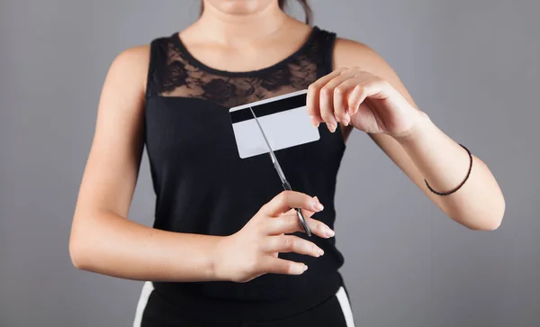 Young woman cutting a credit card.