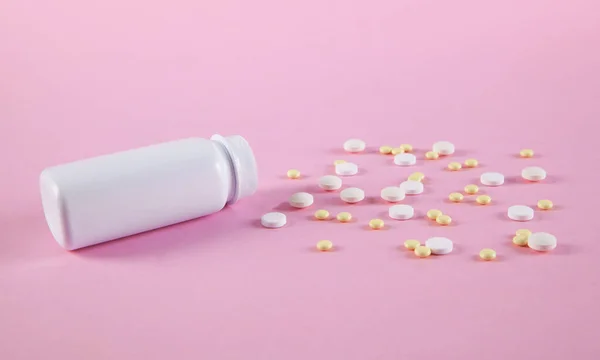 粉红底色白色瓶子中的白色和黄色药丸 — 图库照片
